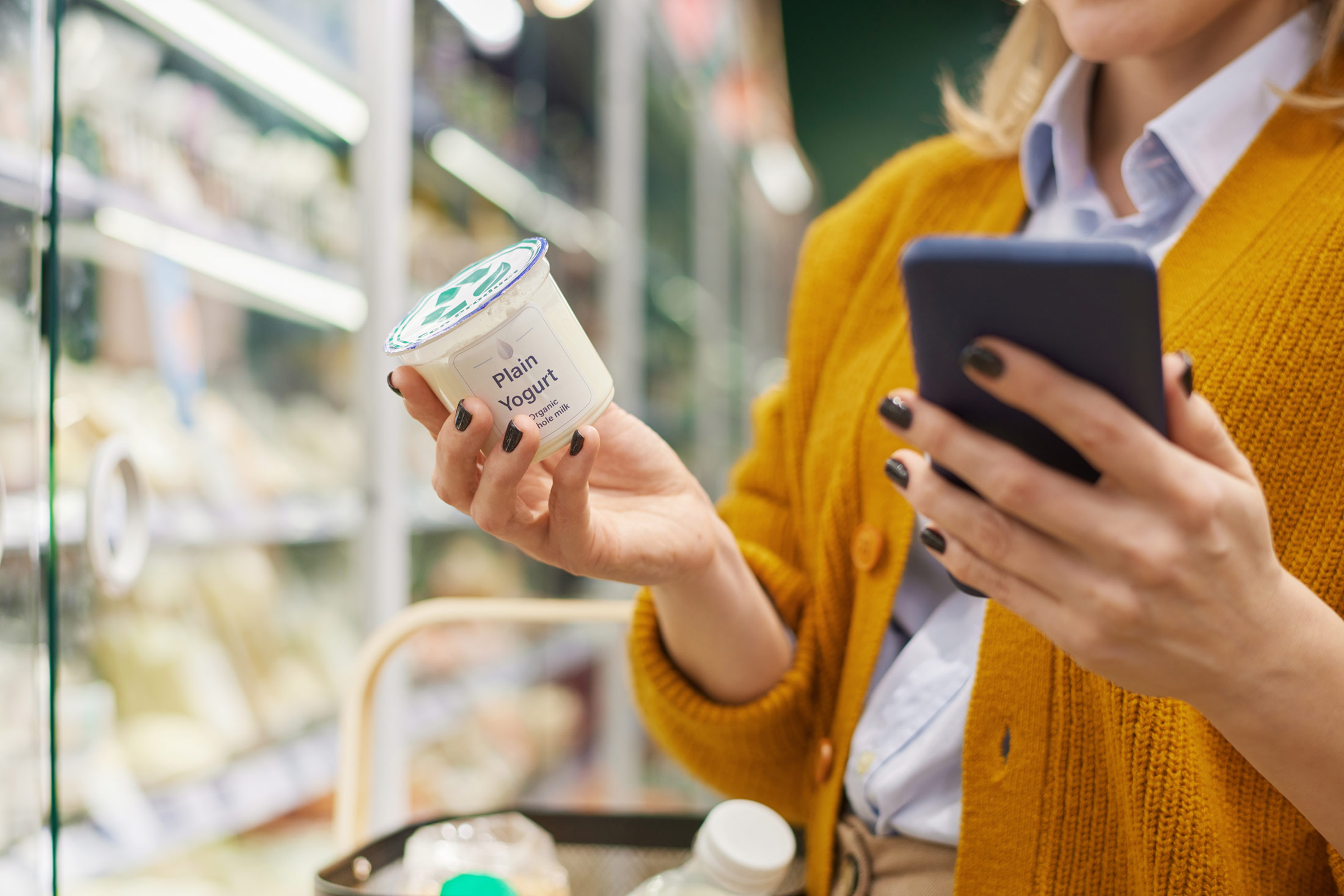 Woman using phone shopping in supermarket